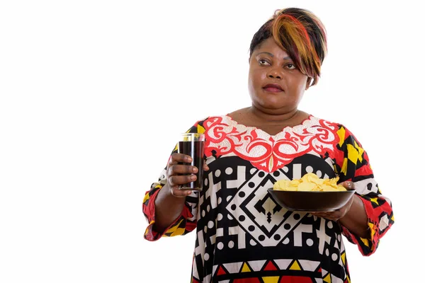 Gorda mujer africana negra sosteniendo tazón de papas fritas y vidrio o — Foto de Stock
