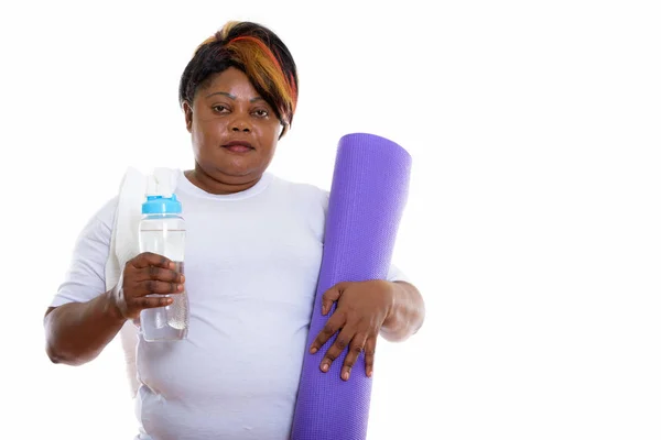 Studio colpo di grasso nero donna africana in possesso di tappetino yoga e wate — Foto Stock