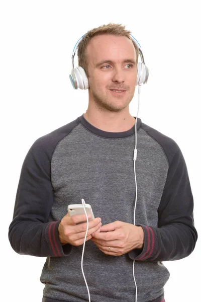 Onnellinen komea valkoihoinen mies kuuntelee musiikkia — kuvapankkivalokuva