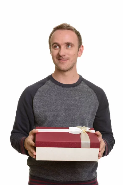 Счастливый кавказский мужчина держит подарочную коробку, думая о Ва — стоковое фото