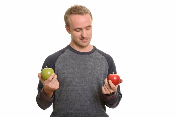 Hombre caucásico guapo elegir entre manzana roja y verde — Foto de Stock