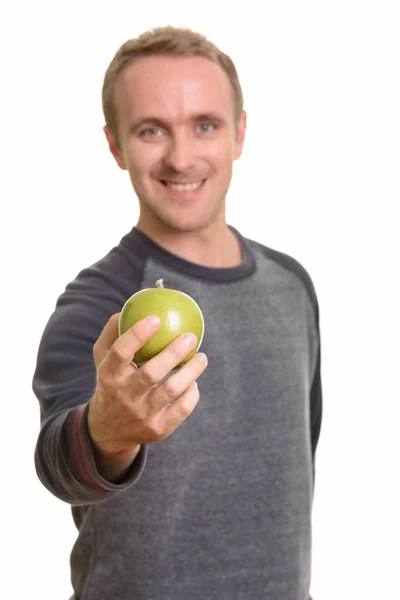 Šťastný pohledný běloch dává zelené jablko — Stock fotografie
