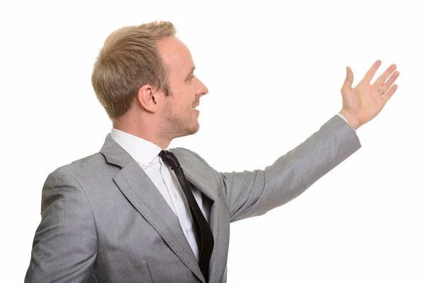 Profile view of handsome Caucasian businessman showing something — Stock Photo, Image