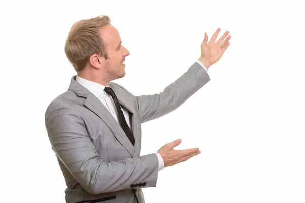 Profile view of handsome Caucasian businessman showing something — Stock Photo, Image