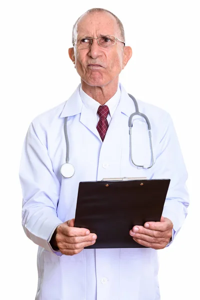 Студийный снимок злого старшего врача, держащего планшет, пока т — стоковое фото
