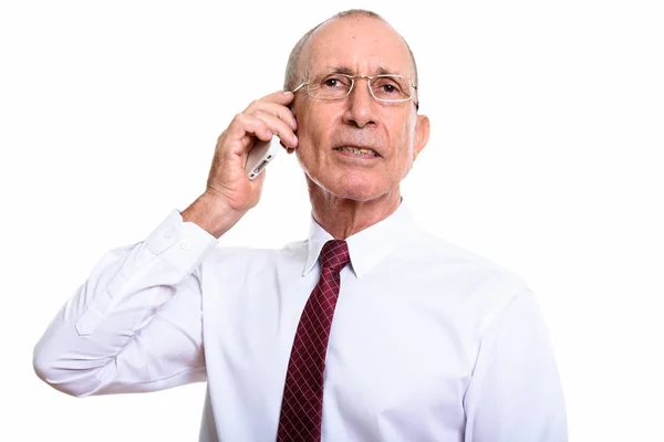 Studio shot van senior zakenman praten op mobiele telefoon — Stockfoto
