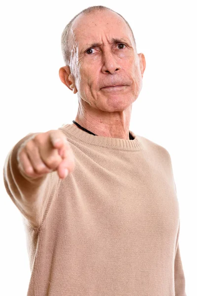 Студийный снимок злого пожилого человека, указывающего пальцем на камеру — стоковое фото