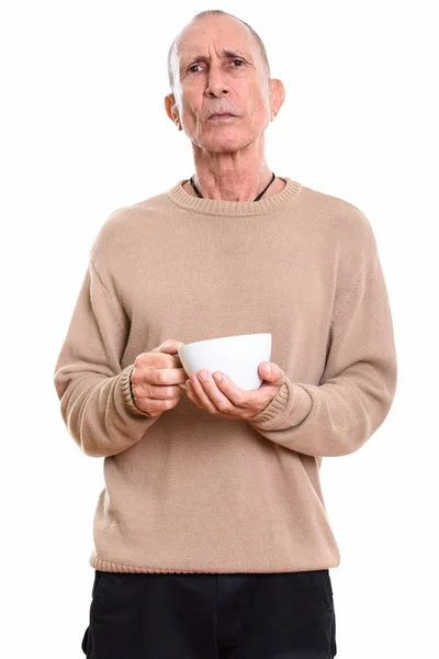 Studio shot di arrabbiato uomo anziano in possesso di tazza di caffè — Foto Stock