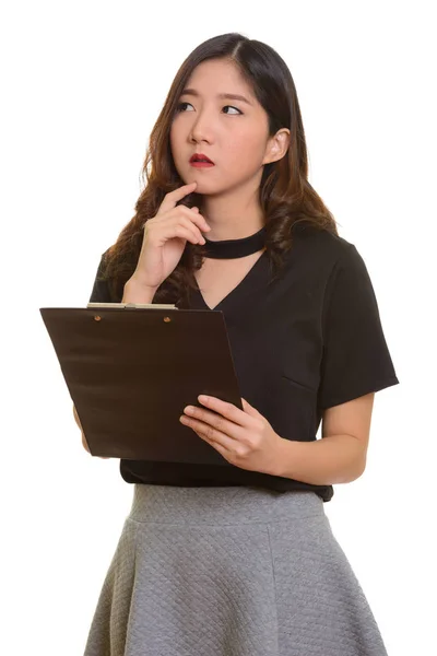 Joven hermosa mujer de negocios asiática sosteniendo portapapeles mientras delgada —  Fotos de Stock