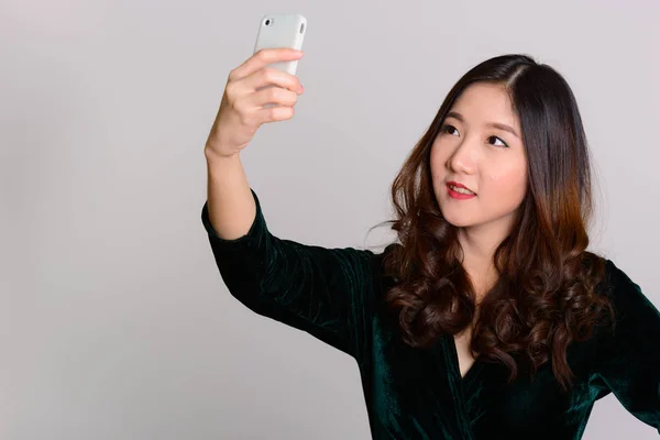 Молодая счастливая азиатка делает селфи с мобильного телефона — стоковое фото
