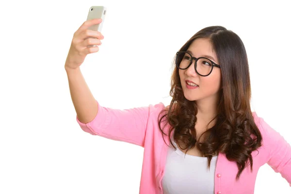 Young happy Asian woman taking selfie with mobile phone — Stock Photo, Image