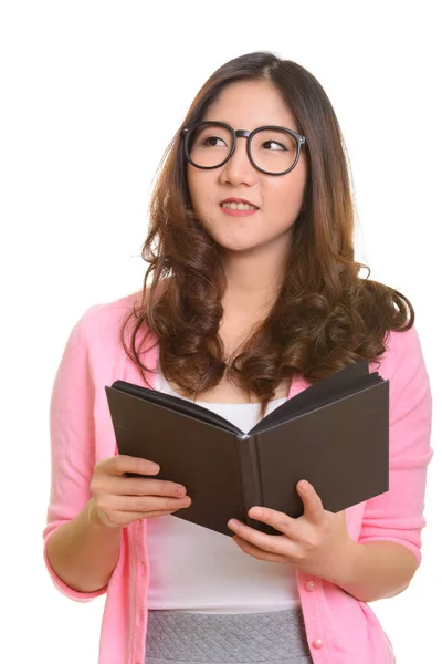 Młody szczęśliwy Azji kobieta gospodarstwa książki podczas myślenia — Zdjęcie stockowe