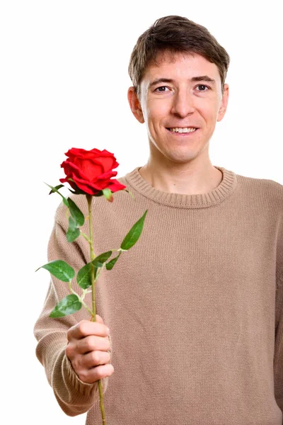 Studioaufnahme eines glücklichen Mannes, der mit roter Rose lächelt — Stockfoto