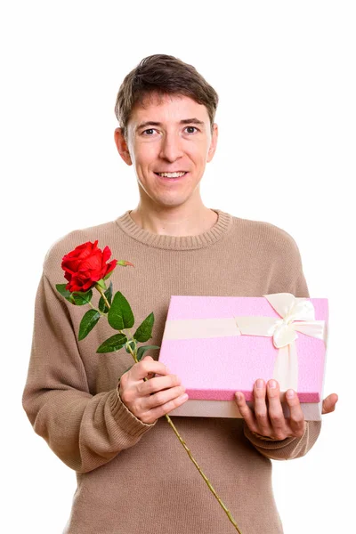 Feliz hombre sonriendo mientras sostiene rosa roja y caja de regalo listo para — Foto de Stock