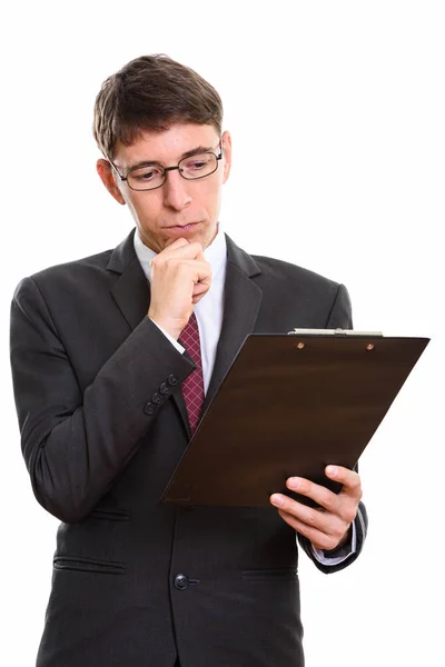 Captura de estudio de hombre de negocios leyendo en el portapapeles mientras pensaba —  Fotos de Stock