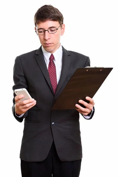 Студийный снимок бизнесмена, держащего буфер обмена при помощи мобильного телефона — стоковое фото