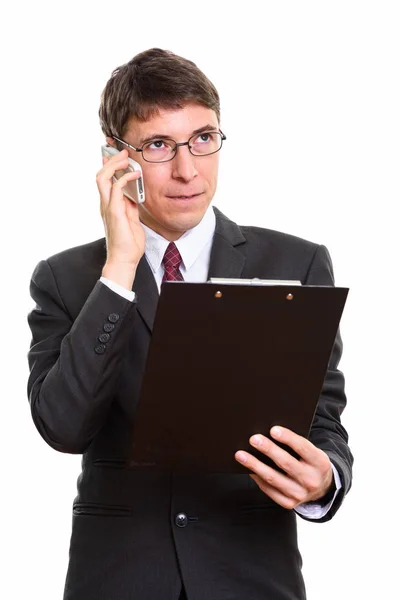 Студийный снимок вдумчивого бизнесмена, держащего планшет и говорящего — стоковое фото