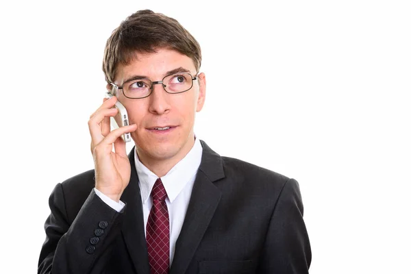 Студийный снимок бизнесмена, разговаривающего по мобильному телефону во время размышлений — стоковое фото