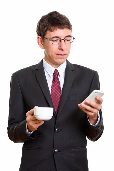 Studio colpo di uomo d'affari utilizzando il telefono cellulare mentre tenendo coff — Foto Stock