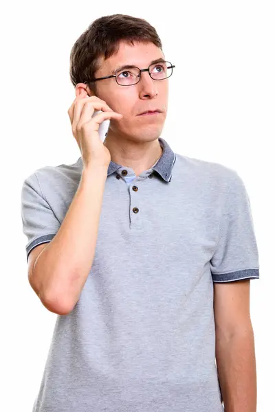Estúdio tiro de homem falando no telefone celular enquanto pensa — Fotografia de Stock
