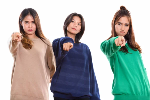 Studio πυροβολισμό τριών φίλων Νεαρά ασιατικές γυναίκα που δείχνει δάχτυλο σε — Φωτογραφία Αρχείου
