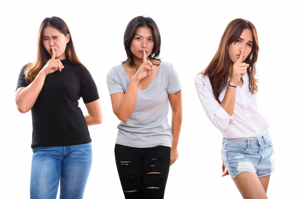Studio schot van drie jonge Aziatische vrouw vrienden met vinger op li — Stockfoto