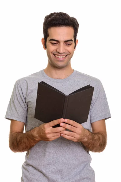 Young happy Persian man reading book — Stock Photo, Image