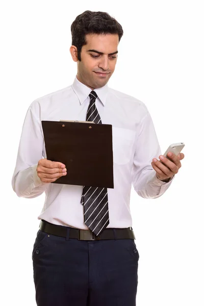 Fiatal perzsa üzletember írótáblával és mobiltelefonnal — Stock Fotó
