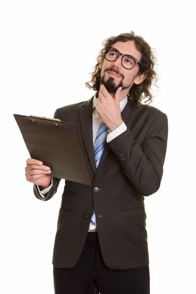 Handsome Caucasian businessman reading clipboard while thinking — Stock Photo, Image