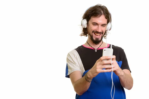 Gelukkig knap blanke man met behulp van mobiele telefoon terwijl u luistert — Stockfoto