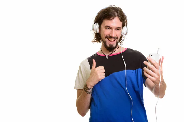 Feliz guapo caucásico hombre sosteniendo el teléfono móvil y escuchando —  Fotos de Stock