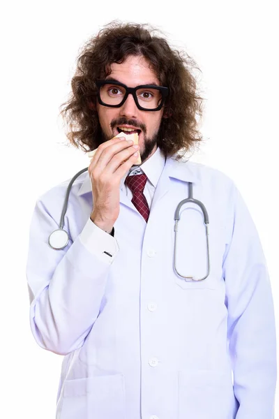 Студийный снимок счастливого человека доктор улыбается и ест сэндвич — стоковое фото