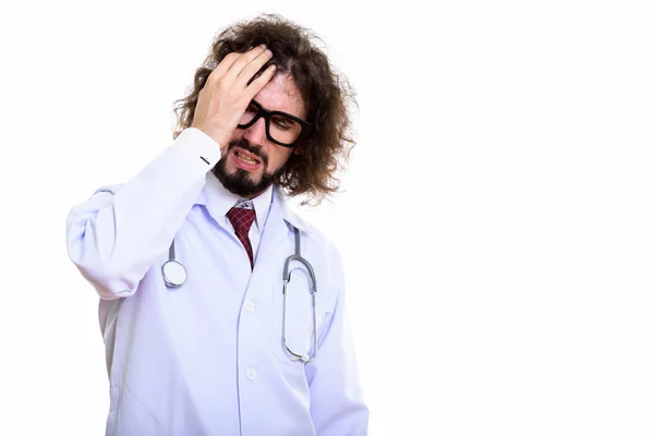 Студійний знімок лікаря-чоловіка, який виглядає напруженим під час покриття обличчя — стокове фото