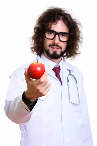 Студийный снимок красивого врача, дающего красное яблоко с фокусом — стоковое фото