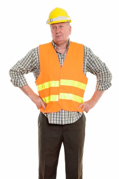 Studio shot of mature man construction worker standing while thi — Stock Photo, Image