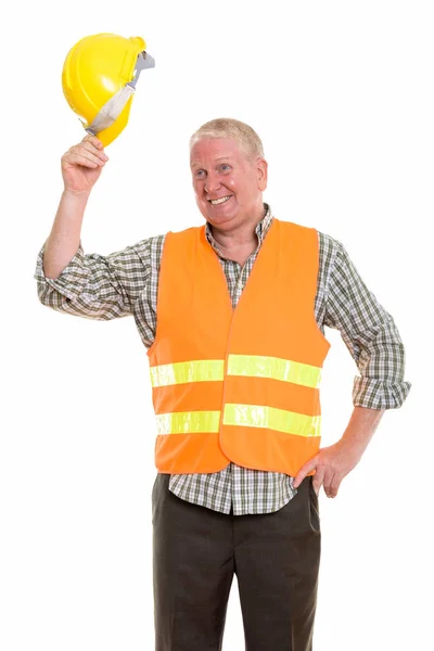 Pensativo feliz hombre maduro trabajador de la construcción sonriendo mientras st — Foto de Stock
