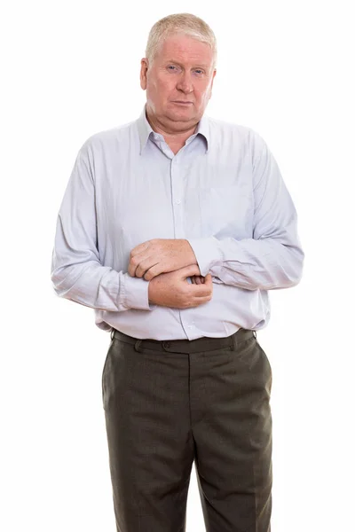 Studio shot of mature man standing while fixing sleeve — Stock Photo, Image