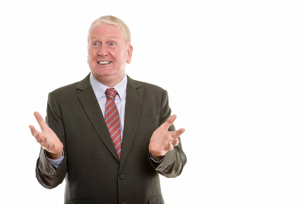 Studio shot of happy mature businessman smiling while gesturing — Stock Photo, Image