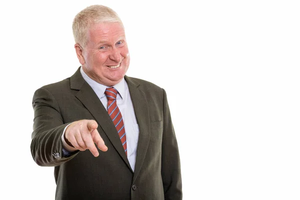 Studio shot of happy mature businessman smiling while pointing a — Stock Photo, Image