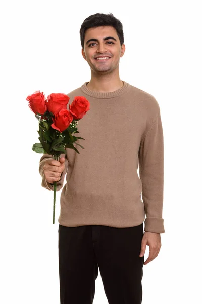 Joven hombre persa feliz sosteniendo rosas rojas listo para San Valentín —  Fotos de Stock