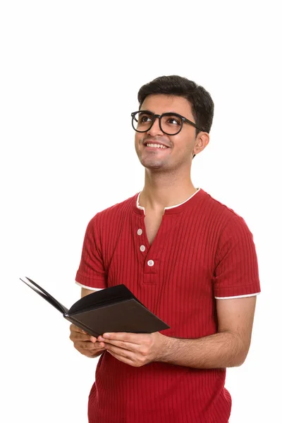 Joven hombre persa feliz sosteniendo libro mientras piensa — Foto de Stock