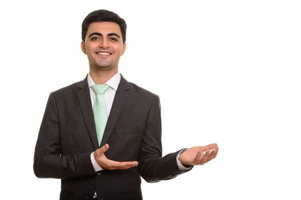 Молодой счастливый персидский бизнесмен показывает что-то — стоковое фото