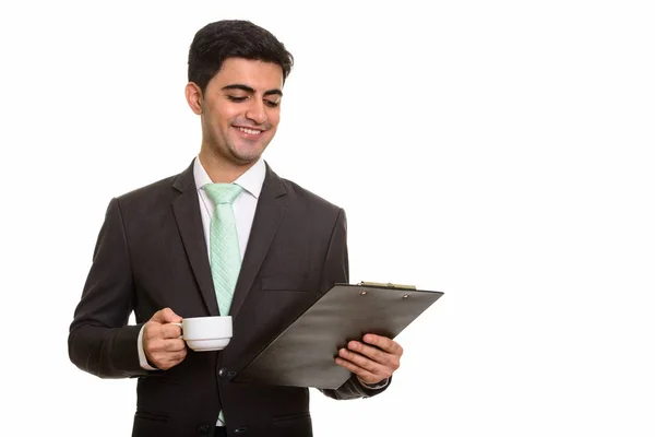 Joven feliz empresario persa leyendo portapapeles mientras sostiene — Foto de Stock
