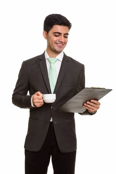 Joven feliz empresario persa leyendo portapapeles mientras sostiene — Foto de Stock