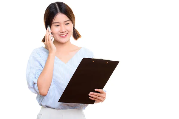 Giovane donna asiatica felice sorridente durante la lettura sugli appunti e t — Foto Stock
