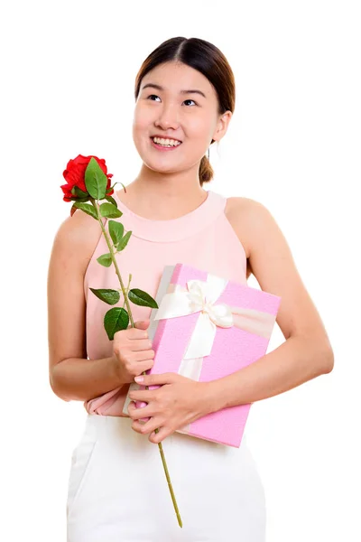 Młoda kobieta azjatyckich szczęśliwy uśmiechający się i myślenia trzymając r czerwony — Zdjęcie stockowe
