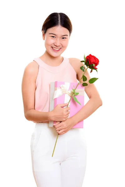 Młodych Asian kobieta szczęśliwy uśmiechający się trzymając czerwonych róż i prezent — Zdjęcie stockowe