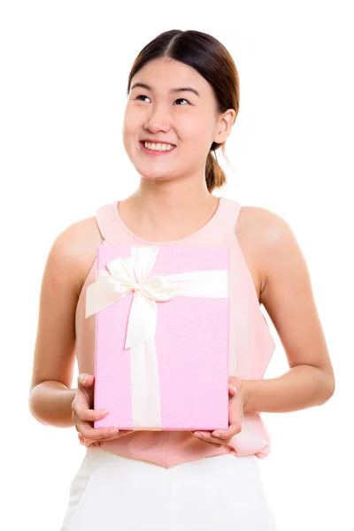 Pensativo jovem feliz asiático mulher sorrindo e segurando caixa de presente — Fotografia de Stock