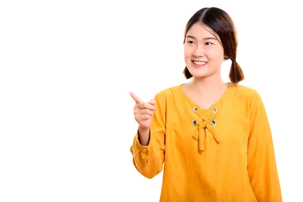 工作室拍摄的年轻快乐的亚洲女人微笑着指向 fi — 图库照片