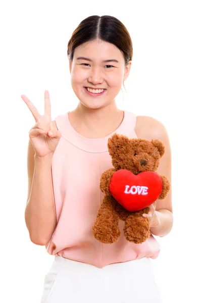 Tineri fericit asiatic femeie zâmbind și holding ursuleț cu auz — Fotografie, imagine de stoc